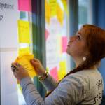 Bethany Sonsini Goodrich / Sustainable Southeast Partnership 
Marina Anderson, deputy director of the Sustainable Southeast Partnership, applies sticky notes to a window at an SSP convening.
