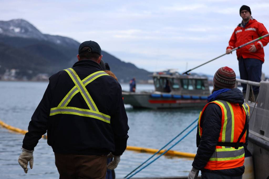 Clarise Larson / Juneau Empire 
Officials from CBJ Docks and Harbors, U.S. Coast Guard and the Alaska Department of Environmental Conservation assist cleanup mitigation and recovery efforts at the National Guard dock Thursday morning where a tugboat sank during the night next to the National Guard dock south of the downtown cruise ship docks.
