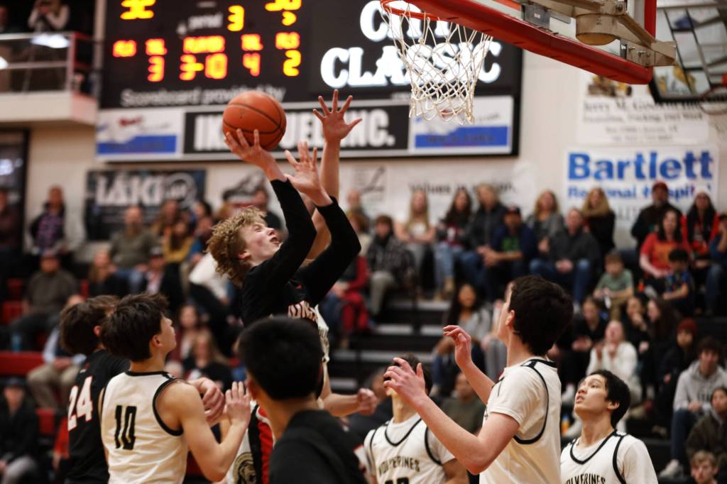 Junior guard Sean Oliver pushes through a crowd of players for a layup during the third period during Thursday nights game against South Anchorage High School during the first night of the Princess Cruises Capital City Classic. (Clarise Larson / Juneau Empire)