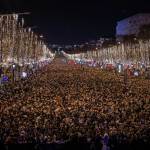 Revelers watch a sound and light show projected on the Arc de Triomphe as they celebrate the New Year on the Champs Elysees, in Paris, France, Saturday, Dec. 31, 2022. (AP Photo/Aurelien Morissard)