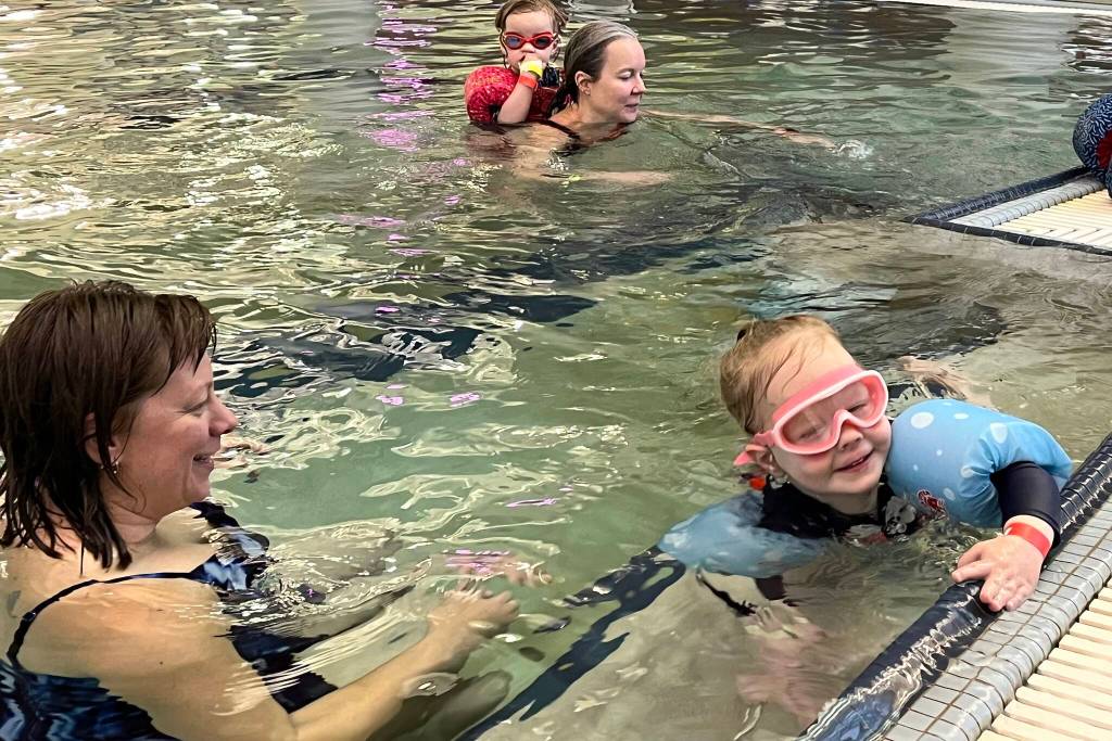 Christal Higdon and daughter Ophelia work on swimming in the deep end during Family Day at the Pool on Saturday at the Dimond Park Aquatic Center. (Jonson Kuhn / Juneau Empire)