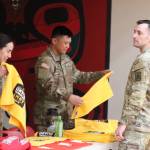 Members of the Alaska Army National Guard, Sgt. Heather Byrd, Staff Sgt. Sean Smack and Private First Class Kyrell De La Rosa hand out t-shirts and towels during Wednesday nights Military Appreciation Night at JDHS. (Jonson Kuhn / Juneau Empire)