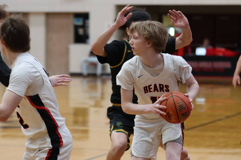 JDHS junior guard Sean Oliver looks for an open pass against Service High School in game two. Oliver would lead the boys team in scores Thursday night with a total of 14 points. (Jonson Kuhn / Juneau Empire)
