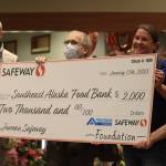 Safeway district manager Stephanie Kennedy and store director Mark Jones hand out a donation check to the Southeast Alaska Foodbank during a grand reopening ceremony on Wednesday. Foodbank manager Chris Schapp accepted the check on behalf of the foodbank. (Jonson Kuhn / Juneau Empire)