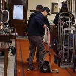 Logistics employees push hand trucks down a hallway at the Alaska State Capitol on Friday after placing chairs in the Senate chamber. (Mark Sabbatini / Juneau Empire)