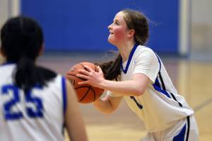 TMHS freshman Cambry Lockhard coils up to launch a 3-pointer early in a home game against Kayhi. (Ben Hohenstatt / Juneau Empire File)