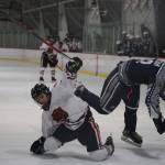 Players from the Juneau-Douglas High School: Yadaa.at Kalé Crimson Bears hockey team and the Soldotna High School Stars take tumble during the third period of their game Saturday afternoon. (Clarise Larson / Juneau Empire)