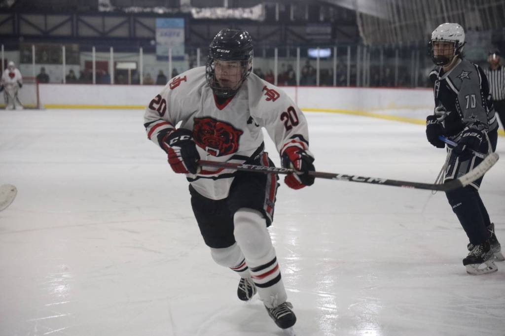 Senior assistant captain Brandon Campbell chases the puck during the first period of Juneau-Douglas High School: Yadaa.at Kalé Crimson Bears hockey game against the Soldotna High School Stars on Saturday. (Clarise Larson / Juneau Empire)