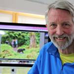 Juneau-based photographer Mark Kelley smiles next to a photo he took that was a part of his award-winning portfolio featured in the 2022 National Wildlife Magazine photo contest. The annual competition that receives more than 30,000 photos submitted by over 3,100 photographers with images coming in from across the globe. (Clarise Larson / Juneau Empire)
