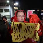 A student holds a sign during a rally at the steps of the Alaska State Capitol Monday evening in advocacy for an increase in the states flat funding via the base student allocation. (Clarise Larson / Juneau Empire)