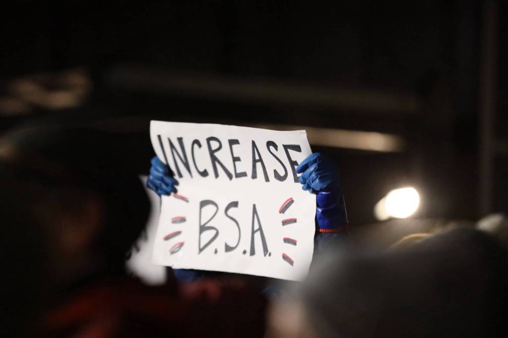 A protester holds a sign advocating for an increase in the states base student allocation during a rally at the steps of the Alaska State Capitol Monday evening. (Clarise Larson / Juneau Empire)