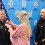 Officer William Hicks stands as his wife Corey Hicks pins a new officers badge to his uniform during a swearing in ceremony for Hicks on Thursday. (Jonson Kuhn / Juneau Empire)
