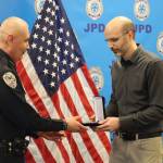 CBJ Deputy City Manager Robert Barr presents a Lifesaving Medal to JPD Chief Ed Mercer on Monday during the JPDs annual award ceremony. Mercer was awarded for his assistance in rescuing passengers from the boat after running aground on Favorite Reef. (Jonson Kuhn / Juneau Empire)