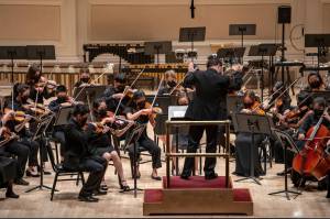 The Juneau student ensemble Aurora Strings warm up on the stage at Carnegie Hall before their 30-minute performance as part of the Sounds of Summer International Music Festival in June of last year. (Photo courtesy of World Projects)