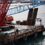 Workers stand on at the edge of a barge that was brought to Juneau to remove the privately owned 107-foot tugboat, theTagish, that sank south of the downtown cruise ship docks in late December. (Clarise Larson / Juneau Empire)