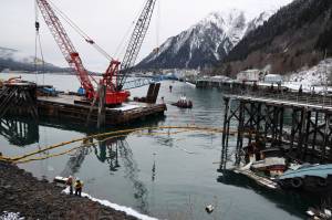 The privately owned 107-foot tugboat, the Tagish, sits partially below the water south of the downtown cruise ship docks Thursday morning as recovery efforts begin by the Coast Guard. (Clarise Larson / Juneau Empire)