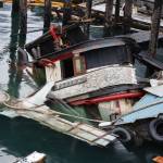 The privately owned 107-foot tugboat, the Tagish, sits partially below the water south of the downtown cruise ship docks Thursday morning as recovery efforts begin by the Coast Guard. (Clarise Larson / Juneau Empire)