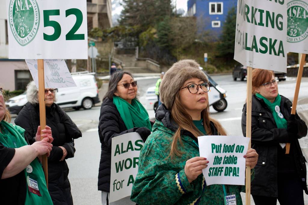 Participants hold signs and chant supportive slogans during a rally for state employees on Friday in front of the Alaska State Capitol. (Mark Sabbatini / Juneau Empire)