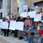 Supporters of a bill that would allow child care providers to participate in collective bargaining with the states Department of Health and establish a state fund to provide grants to childcare providers stand outside the Alaska State Capitol early Friday evening. (Clarise Larson / Juneau Empire)