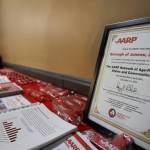 A table of resources and complimentary items was set up at the AARP Alaskas Valentines Day-themed event Tuesday evening to celebrate Juneaus older adult population along with the citys recent commitment to ​​AARPs Network of Age-Friendly States and Communities. (Clarise Larson / Juneau Empire)
