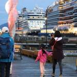 People walk the docks as the sun sets in downtown Juneau in August 2022. The City and Borough of Juneau is seeking comments from residents on how they want the city to spend its marine passenger fee money. (Clarise Larson/ Juneau Empire File)