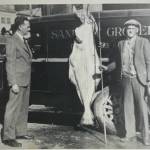 Grocer Gunnar Blomgren displays a large halibut as he stands in front of his Sanitary Grocery delivery truck on Front Street. Photo by Ordway, possibly in 1933. (Courtesy Photo /Gunnar Blomgren Family Collection)