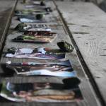 Photos of Daniel Sargent stacked with rocks to keep from blowing away line the picnic tables of the Raven Shelter on Saturday during his memorial service. Daniel was 75-years-old. (Jonson Kuhn / Juneau Empire)