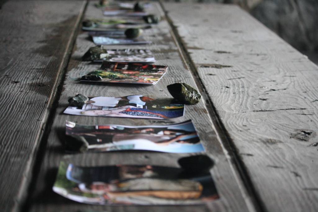 Photos of Daniel Sargent stacked with rocks to keep from blowing away line the picnic tables of the Raven Shelter on Saturday during his memorial service. Daniel was 75-years-old. (Jonson Kuhn / Juneau Empire)