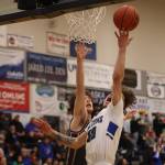 TMHS junior Thomas Baxter (30) rolls the ball off his fingertips and into the hoop while defended by Ketchikan junior Andrew Kleinschmidt-Guthrie in the first half of a home loss to Kayhi. Baxter scored 19 of his 21 total points in the first half.(Ben Hohenstatt / Juneau Empire)