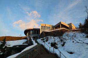 The sun partially sines on the Mendenhall Glacier Visitor Center as it sets Monday evening. Tuesday is the last day for the public to submit comments to the U.S. Forest Service on proposed changes to the Mendenhall Glacier Recreation Area. (Clarise Larson / Juneau Empire)
