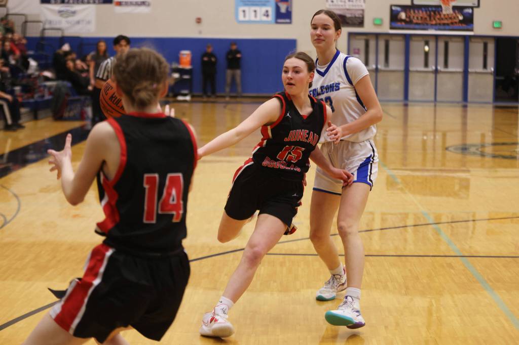 JDHS freshman Gwen Nizich (15) flips the ball to her teammate sophomore Tatum Billings (14) and away from TMHS sophomore Cailynn Baxter (23) in the first half of a Tuesday night game at Thunder Mountain. TMHS would prevail 37-36 despite trailing going into the fourth quarter. (Ben Hohenstatt / Juneau Empire)