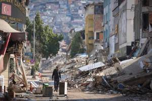 A man walks past destroyed buildings in Antakya, southeastern Turkey, Tuesday, Feb. 21, 2023. Douglas Mertz writes that the disaster offers lessons for Alaskas capital city. (AP Photo / Unal Cam)