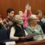 Alla Kalinovska, in the rear center row, takes a photo of the Alaska State Senate chambers on Friday shortly before she and five other Ukrainian refugees were honored during a floor session where state Sen. Jesse Kiehl D-Juneau, read a statement from the group expressing local sponsors for their support. (Mark Sabbatini / Juneau Empire)