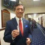 State Sen. Scott Kawasaki, in a hallway in the Alaska State Capitol on Feb. 16 holds up the strip showing he has tested negative for COVID-19. Kawasaki said he opted to take a test that day. (Yereth Rosen / Alaska Beacon)
