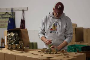 Jonson Kuhn / Juneau Empire 
Southeast Alaska Food Bank director Chris Schapp separates cans of salmon on Monday donated by SeaShare based out of Washington state. Thanks to a recent announcement from the Alaska State Department of Health, Schapps food bank will be one of four food banks to receive much needed financial assistance.