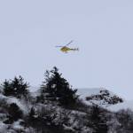 The Alaska Department of Transportation and Public Facilities drops explosives via helicopter to trigger controlled avalanches above Thane Road Tuesday afternoon. (Clarise Larson / Juneau Empire)