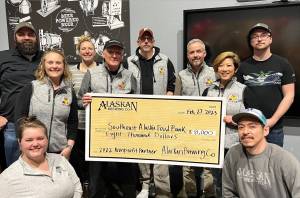 Alaskan Brewing Co. staff presents a check to Southeast Alaska Food Bank director Chris Schapp on Tuesday as part of the companys Cheers to the Southeast Alaska Food Bank! celebration. The evening also celebrated the selection of Alaskan Brewing Co. next year recipient SEADOGS. (Courtesy Photo / Erin Youngstrom)