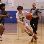 TMHS junior Samuel Lockhart (14)dribbles toward the hoop while defended by Kayhi senior JJ Parker (13). (Ben Hohenstatt / Juneau Empire)