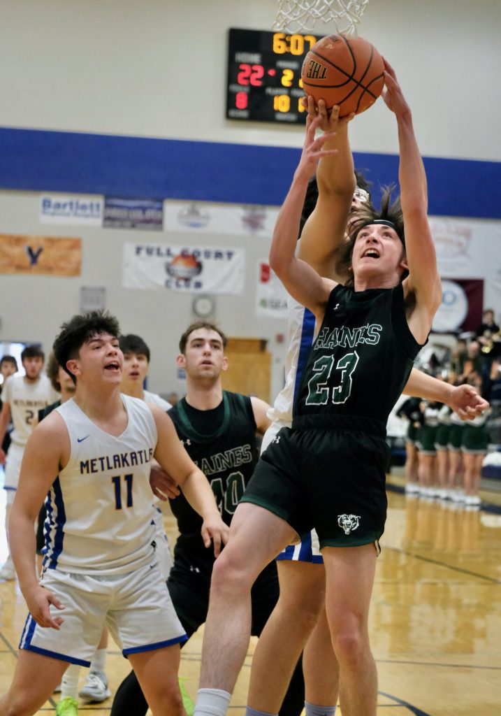 Metlakatlas Aaron OBrien takes a rebound from behind Haines Phoenix Swaner (23) during the Region V tournament on Thursday. (Klas Stolpe / For the Juneau Empire)