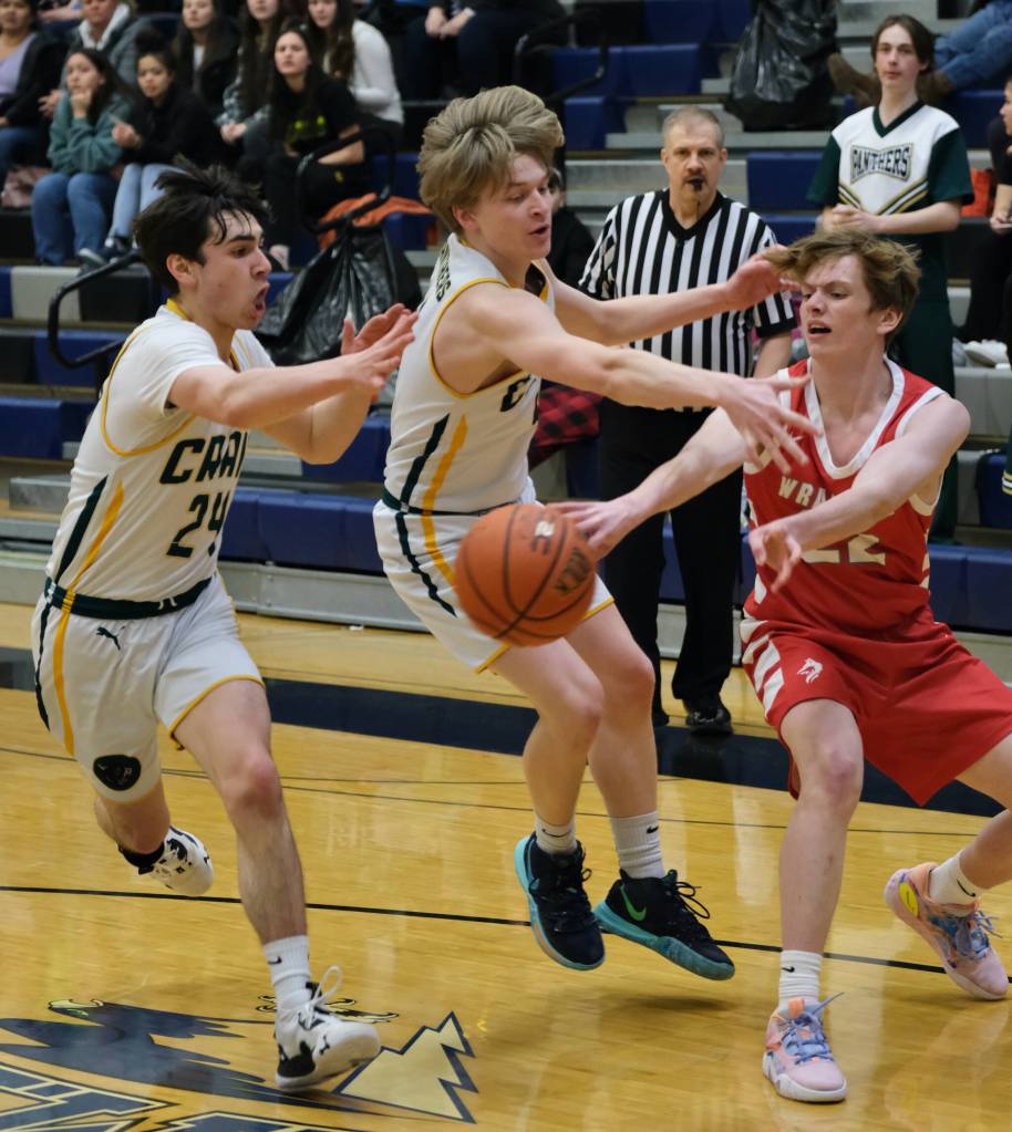 Craig sophomore Ayden Benolken (24) and senior Sam Bass (4) defend a pass by Wrangell sophomore Trevyn Gillen during the Region V basketball tournament Thursday. (Klas Stolpe / For the Juneau Empire)