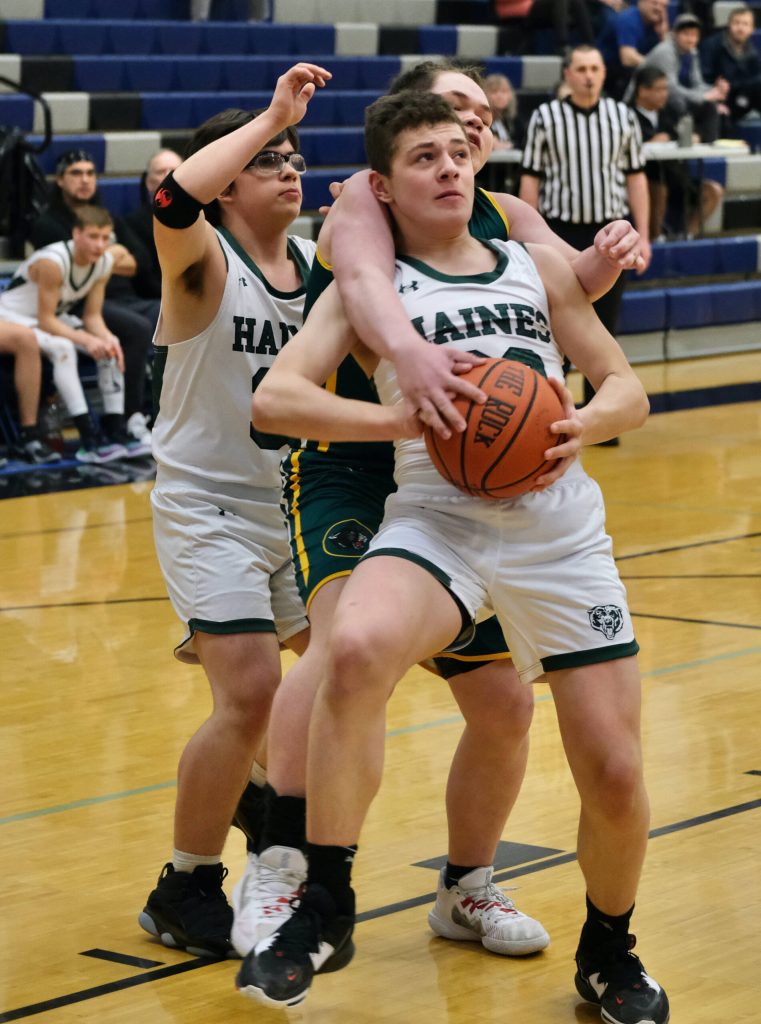 Haines James Stickler is fouled by Craigs Jaxson Fowler during Region V tournament action on Wednesday. (Klas Stolpe / For the Juneau Empire)