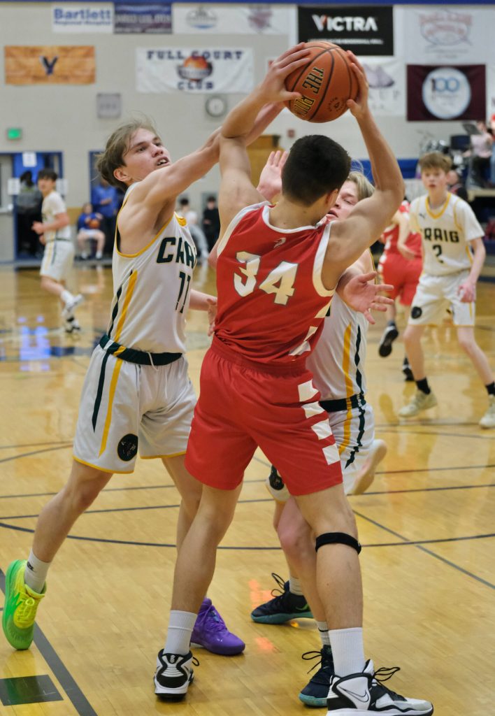 Craigs Jayson Fowler (11) and Sam Bass defend Wrangells Daniel Harrison (34) during the Region V tournament on Thursday. (Klas Stolpe / For the Juneau Empire)