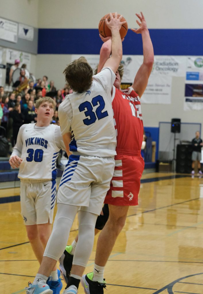Petersburgs Jack Engell challenges a shot by Wrangells Ethan Blatchley (12) during Region V tournament action on Wednesday.(Klas Stolpe / For the Juneau Empire)