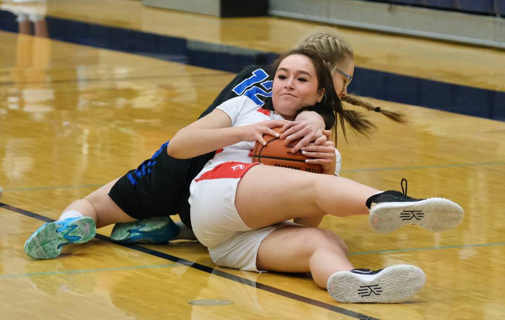 Wrangell High School junior Kayla Meissner (23) and Petersburg High School sophomore Eleanor Kandoll (12) battle for a loose ball during the Lady Wolves 48-10 win over the Lady Vikings in the Region V 2A/4A Basketball Tournament on Wednesday at Thunder Mountain High School in Juneau. (Klas Stolpe for the Juneau Empire)