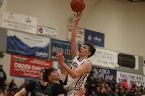Ketchikan High Schools Marcus Stockhausen takes the ball in for a layup against Thunder Mountain for their final match up in this years 4A Region V tournament. Ketchikan advances to play JDHS Friday night for the championship game. (Jonson Kuhn / Juneau Empire)