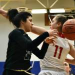 Haines senior Grace Long Godinez (2) passes around the defense of Wrangell senior Kiara Harrison (11) during an elimination game at the Region V tournament on Friday. (Klas Stolpe / For the Juneau Empire)