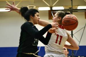 Haines senior Grace Long Godinez (2) passes around the defense of Wrangell senior Kiara Harrison (11) during an elimination game at the Region V tournament on Friday. (Klas Stolpe / For the Juneau Empire)