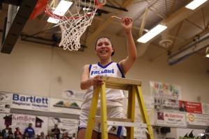 TMHS senior Kiara Kookesh holds up a strand from the net after securing the win against JDHS on Friday for the two teams final math up in the 4A Region V tournament. Kookesh tied for the lead in scoring with a total of 12 points. (Ben Hohenstatt / Juneau Empire)
