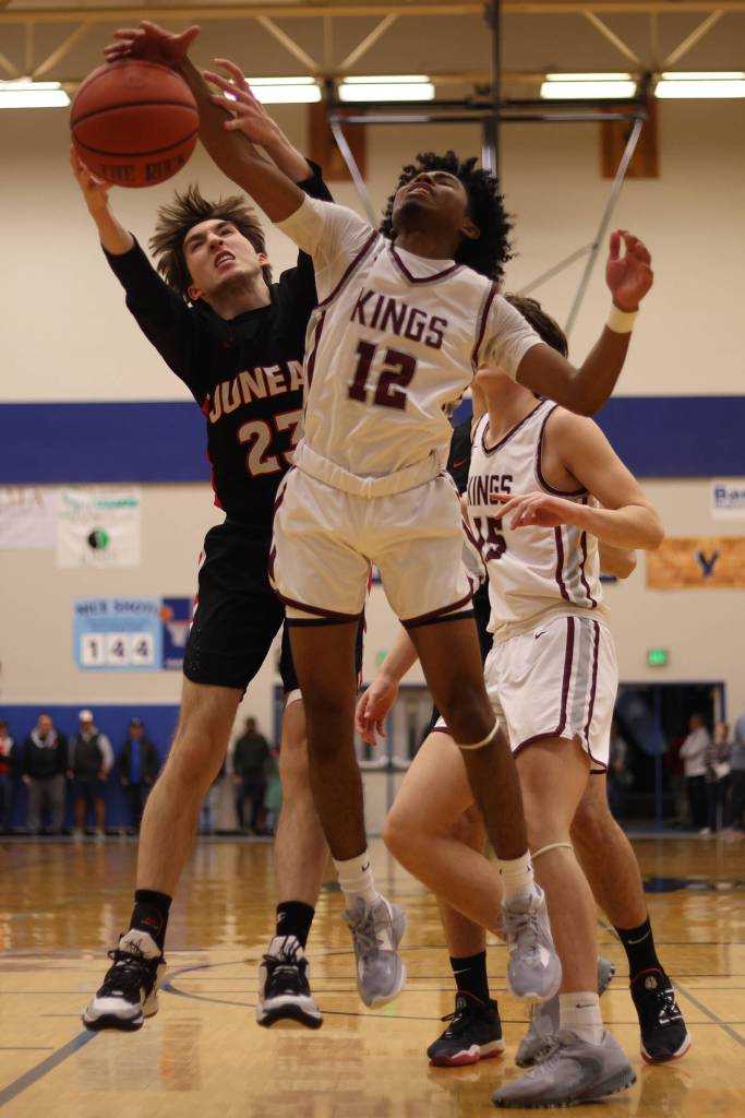 JDHS Joseph Aline (23) and Kayhi senior JJ Parker (12) battle for a board in the first half of the Region V 4A Championship game. (Ben Hohenstatt / Juneau Empire)