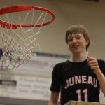 JDHS junior Sean Oliver (11) holds string from the championship net after a win against Ketchikan High School, making the Crimson Bears this years Region V 4A Tournament champs. Oliver finished the game with 30 points, six 3-pointers and a fourth-quarter slam dunk. (Jonson Kuhn / Juneau Empire)